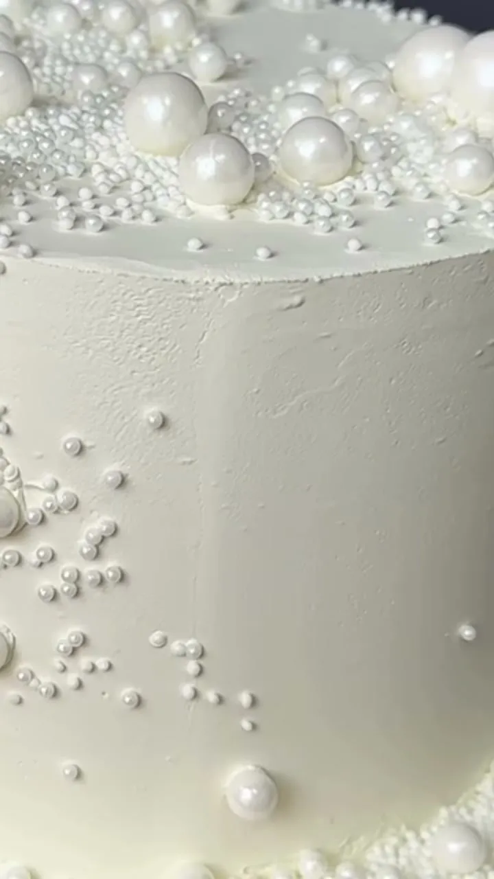 Detalle de una tarta blanca cubierta de perlas de azúcar de varios tamaños